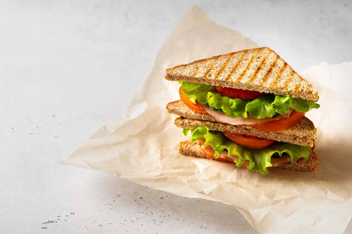 Sandwich toast with fresh salad, tomato, bacon on white background, copy space